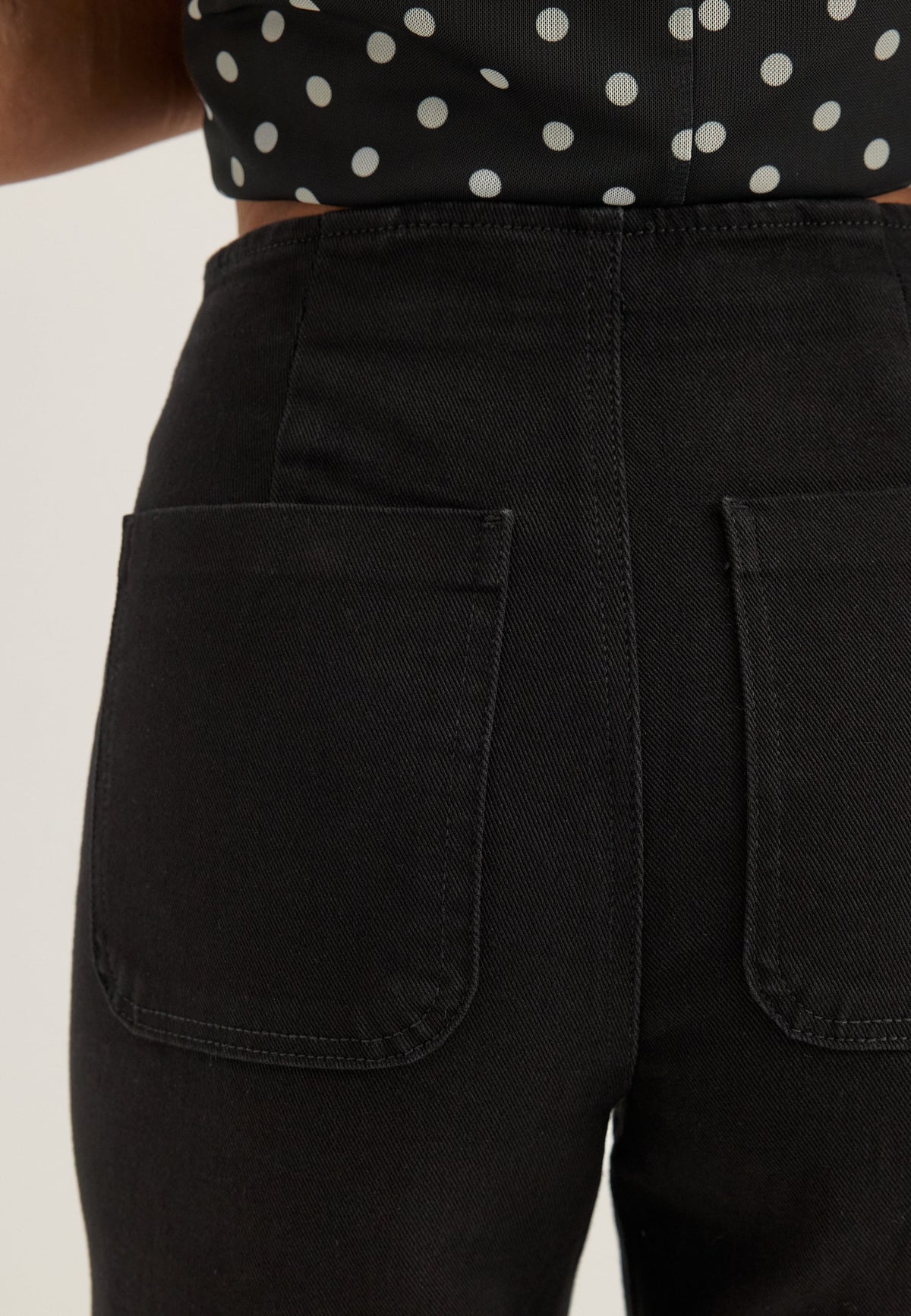 Mustien leveälahkeisten farkkujen denimin ja lahkeen yksityiskohta