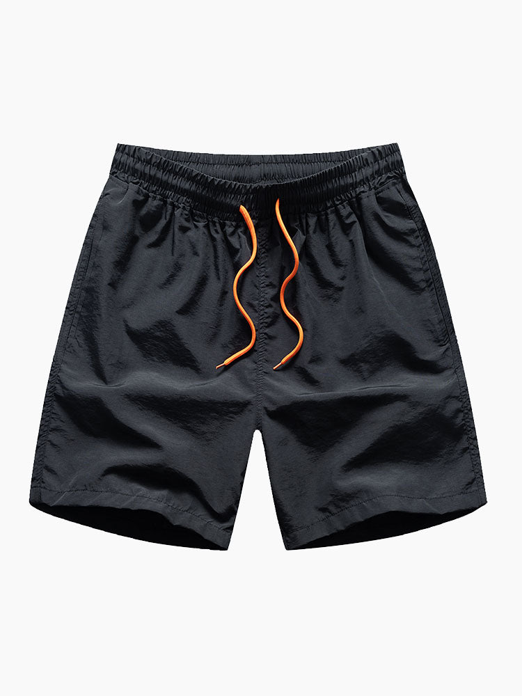 Mustat uimashortsit oranssilla kiristysnyörillä edestä