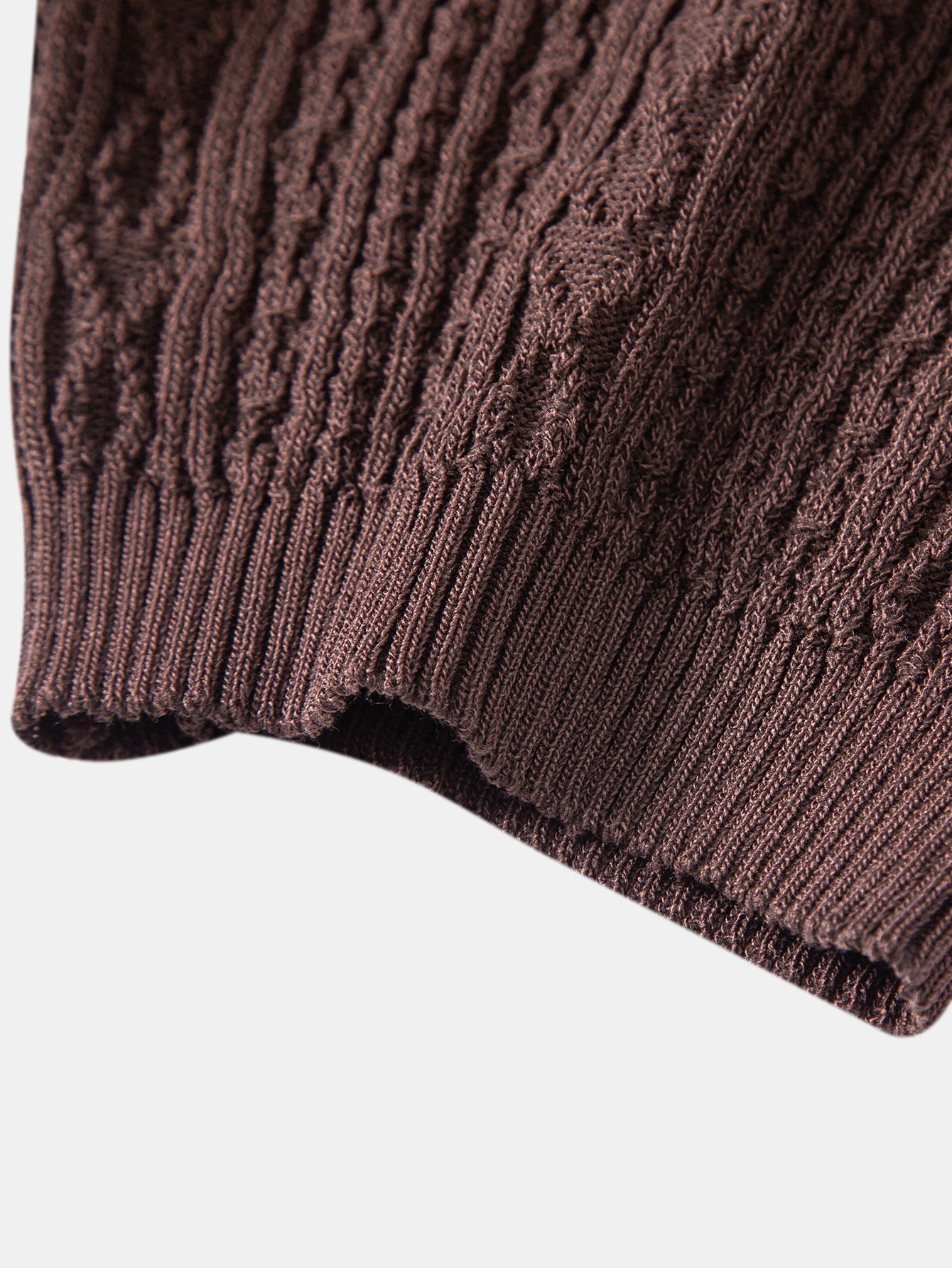 Kahvinruskean jacquard-neulepikeepaidan ribbineulotun hihansuun yksityiskohta