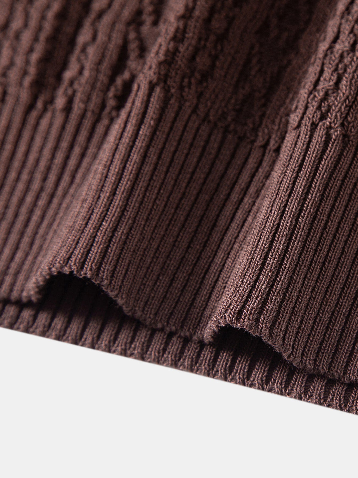 Kahvinruskean jacquard-neulepikeepaidan ribbineulotun helman yksityiskohta
