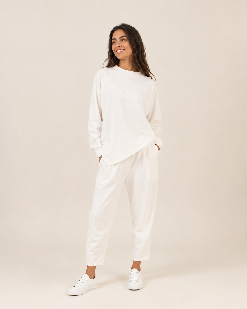 Valkoinen epäsymmetrinen pitkähihainen paita ja yhteensopivat housut aikuisen mallin yllä.